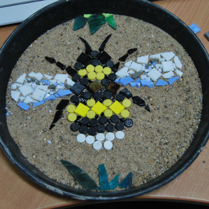 Gefangene an einem Arbeitstisch bearbeiten ihre Kunstwerke