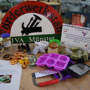 Schild der Förderwerkstatt JVA Münster und diverse Utensilien zur Seifenherstellung