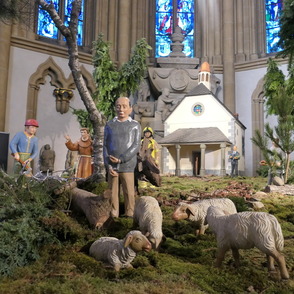 Krippe im Paderborner Dom mit geschnitztem Inhaftierten im Vordergrund
