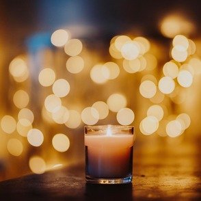 Kerze vor unscharfer Lichterkette