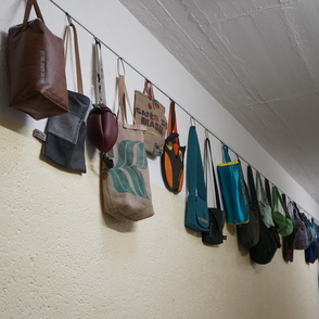 Taschen aufgehängt an einer Schnur an der Wand