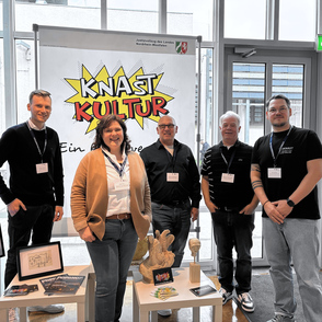 Das Team Knastkultur und Podknast vor dem neuen Logo Knastkultur