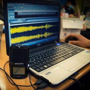 Laptop mit Tonaufnahmeprogramm und Mikrofon.
