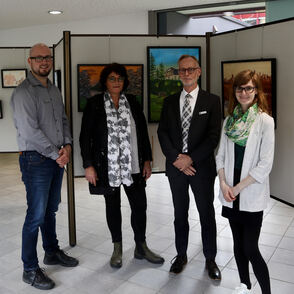 Gruppenfoto der Organisatoren der Ausstellung vor Kunstwerken
