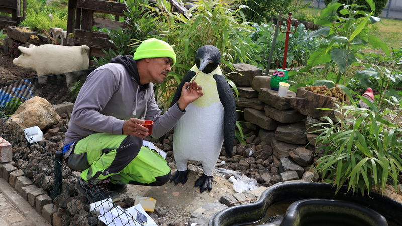 Rinaldo, der Künstler und Initiator, bei der Bemalung der Skulptur des Pinguins.