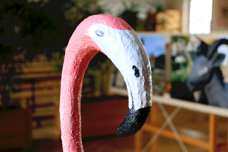 Der Flamingo stand in der Ausstellung in Haus 1. Hier ist im Bild der Kopf der Skultur zu sehen und im Hintergrund gehängte Fotografien.