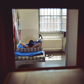 Gefangener auf dem Bett im Haftraum