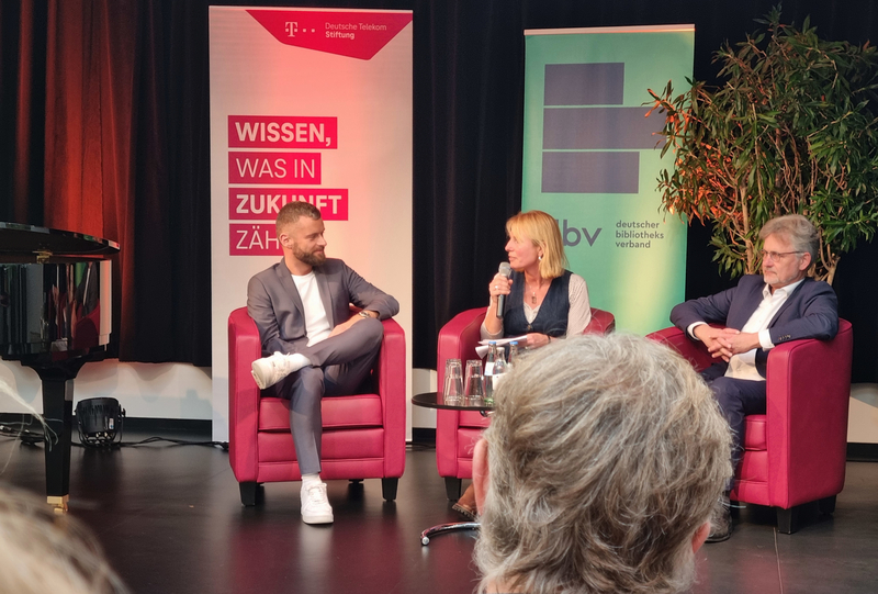 Jacob Chammon als Geschäftsführer der Deutschen Telekom Stiftung und Dr. Frank Mentrup als Präsident des Deutschen Bibliotheksverbandes e.V. und beide als Mitglied der Jury zur Auswahl des Gewinners des Preises zur Bibliothek des Jahres in einer Diskussionsrunde mit der Moderatorin Jenny Heimann.