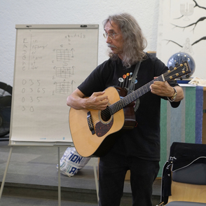 Peter Bursch Portrait mit Gitarre und Noten