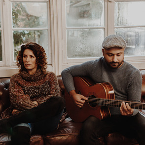 Duo "Melarima" mit Gitarre auf einer Couch