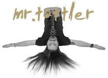 K&uuml;nstler auf dem R&uuml;cken liegend in SW mit farbigemn Schriftzug "mr. tottler"