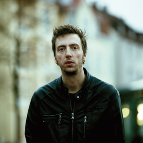 portrait des K&uuml;nstlers vor einem unscharfen urbanen Hintergrund