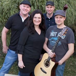 Gruppenbild vor einem Busch mit Instrumenten