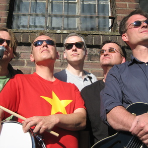 Gruppenfoto von unten nach oben fotografiert vor einer Ziegelfassade