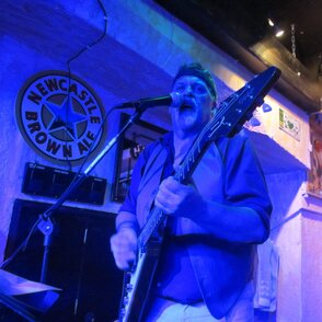 Bandmitglied de "Tres Hombres" auf einer blau ausgeleuchteten B&uuml;hne