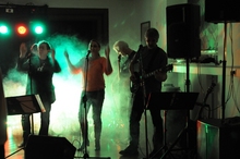 Bandfoto während eines Auftritts, von Nebel umhüllt bunt ausgeleuchtet