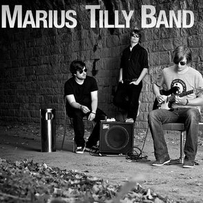 Bandfoto in SW in einer Unterführung mit Ampifiler in der Mitte und Logo
