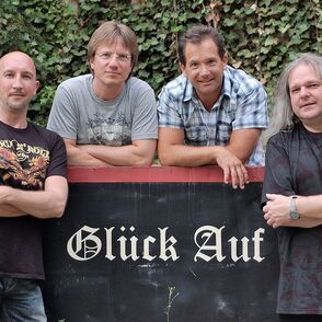 Gruppenbild der Band um eine Bergbaulohre