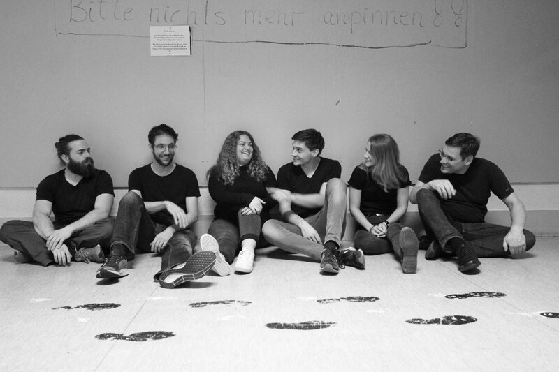 Mitglieder des Improvisationstheaters Spontanindustrie sitzend auf dem Boden SW
